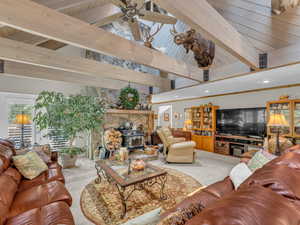 Living area with carpet, a wood stove, a ceiling fan, and recessed lighting