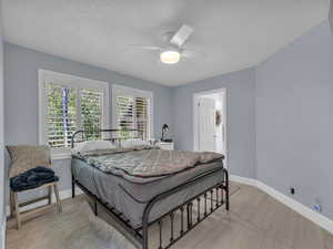 Bedroom with ceiling fan and a textured ceiling
