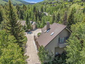 Aerial view of property and surrounding area with a heavily wooded area and a mountainous background