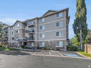 View of apartment building / complex with uncovered parking
