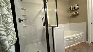 Full bathroom featuring a bath and a stall shower