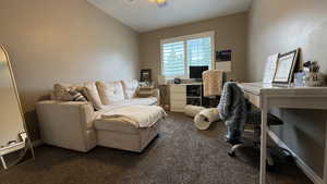 Office featuring dark carpet and vaulted ceiling