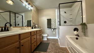 Bathroom featuring a shower stall, double vanity, and a bath