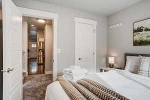 Carpeted bedroom with stainless steel fridge and baseboards