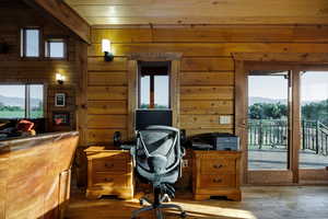 Office area featuring a mountain view, wooden walls and plenty of natural light