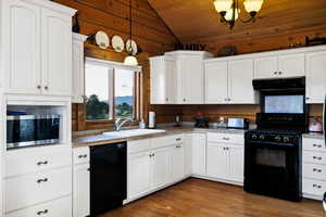 Kitchen featuring black appliances, exhaust hood, vaulted ceiling, white cabinets, and wooden ceiling