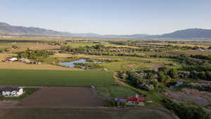 Aerial view of property and surrounding area featuring rural landscape and a water and mountain view