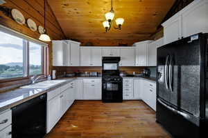 Kitchen featuring black appliances, vaulted ceiling, exhaust hood, wooden ceiling, and white cabinets