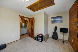 Den with loft access and carpet floors