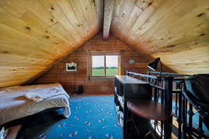 Carpeted Loft featuring wood walls, lofted ceiling, and wooden ceiling