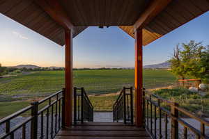 Deck at dusk with agricultural area, a view of countryside, and a mountain view