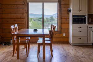 Dining space with hardwood flooring, wood walls, and a mountain view
