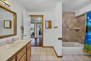 Full bath with tile patterned flooring, vanity, and shower / tub combo with curtain