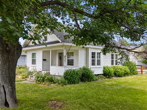 View of front of home with a shingled roof and a porch