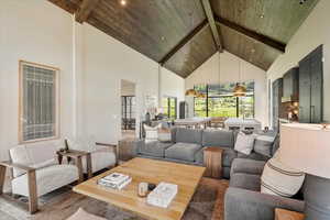 Living room featuring high vaulted ceiling, a wooden ceiling with exposed beams, wood finished floors, and recessed lighting