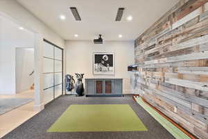 Playroom featuring recessed lighting, carpet, golf simulator, and wood walls