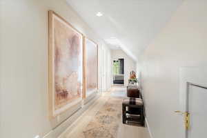 Hall with recessed lighting and lofted ceiling