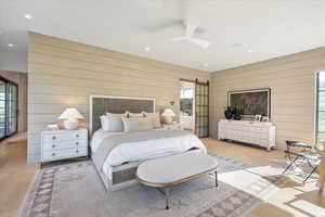 Bedroom with wooden walls, multiple windows, light wood-type flooring, recessed lighting, and ceiling fan