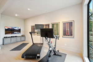 Exercise room with baseboards and recessed lighting