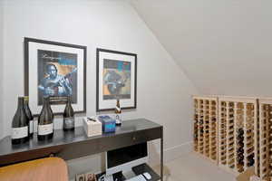 Wine room with lofted ceiling and baseboards