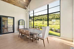 Dining area with high vaulted ceiling and light wood finished floors