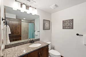 Full bathroom featuring vanity, a textured ceiling, and curtained shower