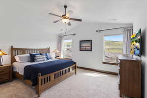Bedroom with vaulted ceiling, carpet floors, and ceiling fan