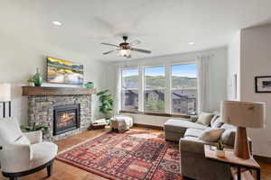 Living area with ceiling fan, a fireplace, wood finished floors, and recessed lighting