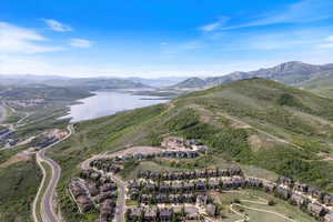 Aerial view of property and surrounding area featuring a water and mountain view and nearby suburban area