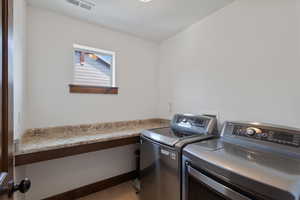 Laundry room featuring washing machine and dryer and light tile patterned floors