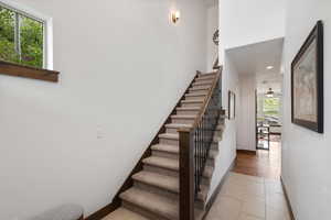 Stairs featuring tile patterned floors, recessed lighting, and a ceiling fan