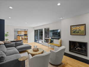 Living area with wood finished floors, recessed lighting, and a fireplace