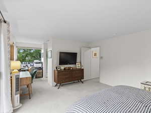 Primary Bedroom featuring light carpet and a desk