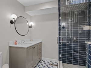 Full bathroom featuring a stall shower, vanity, and tile patterned floors