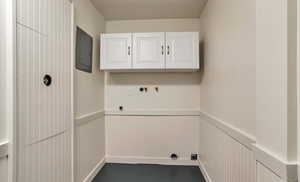 Washroom with electric panel, cabinet space, wainscoting, electric dryer hookup, and hookup for a washing machine