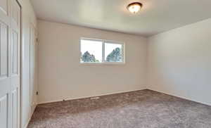 Unfurnished bedroom with carpet flooring and baseboards