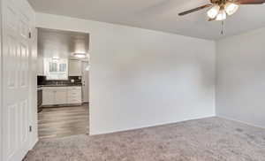 Unfurnished room with ceiling fan and light carpet