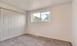 Unfurnished bedroom with carpet and a closet