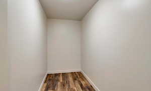 Empty room featuring dark wood-type flooring and baseboards