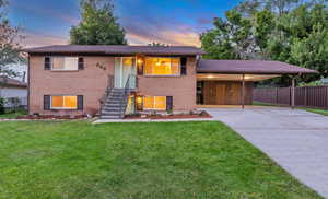 View of front of house featuring brick siding, concrete driveway, and an attached carport