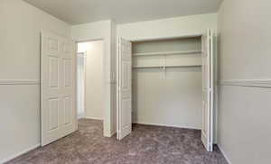 Unfurnished bedroom featuring carpet and a closet