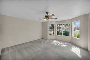 Unfurnished room with healthy amount of natural light, carpet, ceiling fan, a textured ceiling, and recessed lighting