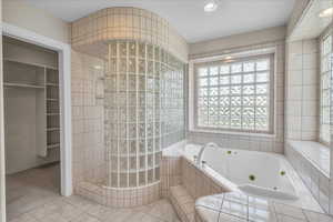 Bathroom featuring a whirlpool tub, walk in shower, tile patterned flooring, plenty of natural light, and recessed lighting