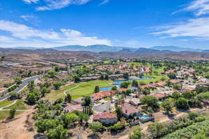 Aerial view of residential area featuring a water and mountain view and a golf course