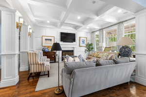 Living room featuring a decorative wall, beam ceiling, recessed lighting, dark wood-style floors, and coffered ceiling