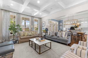 Living room featuring ornamental molding, coffered ceiling, beam ceiling, healthy amount of natural light, and recessed lighting