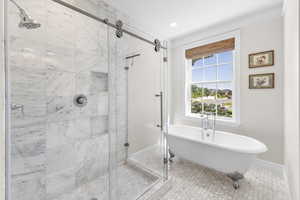 Bathroom with a stall shower, a freestanding bath, tile patterned flooring, and recessed lighting