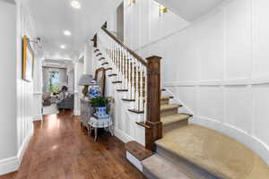 Stairs featuring a decorative wall, wood finished floors, and recessed lighting