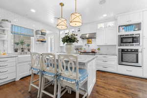 Kitchen with appliances with stainless steel finishes, extractor fan, open shelves, wood ceiling, and dark wood-style flooring