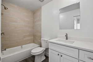 Bathroom featuring vanity,  shower combination, and a textured ceiling